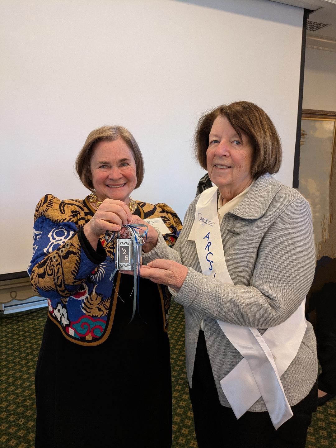 Leslie Petter, ARCS Light 2024 presenting lantern to Sally McDaniel, ARCS Light 2025 Leslie Petter, ARCS Light 2024 presenting lantern to Sally McDaniel, ARCS Light 2025